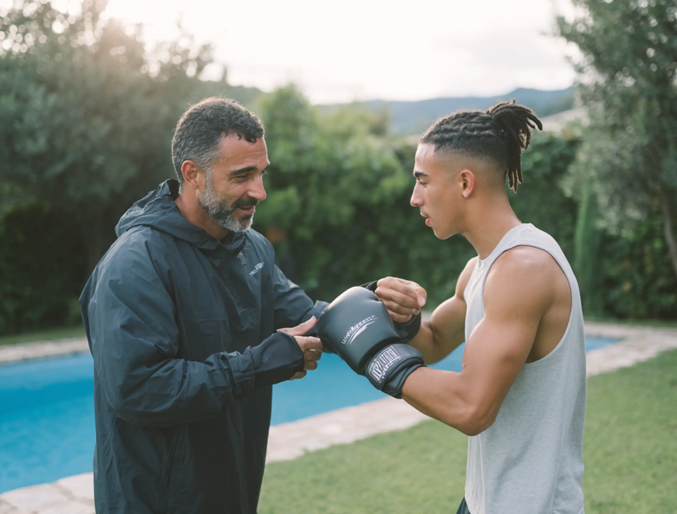 Coach helping a student put on boxing gloves during home training in Barcelona. — GP360 Barcelona